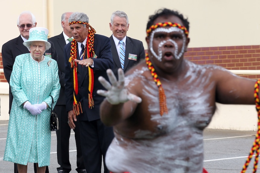 Queen Elizabeth watches an Aboriginal dancer on her final visit to Australia.