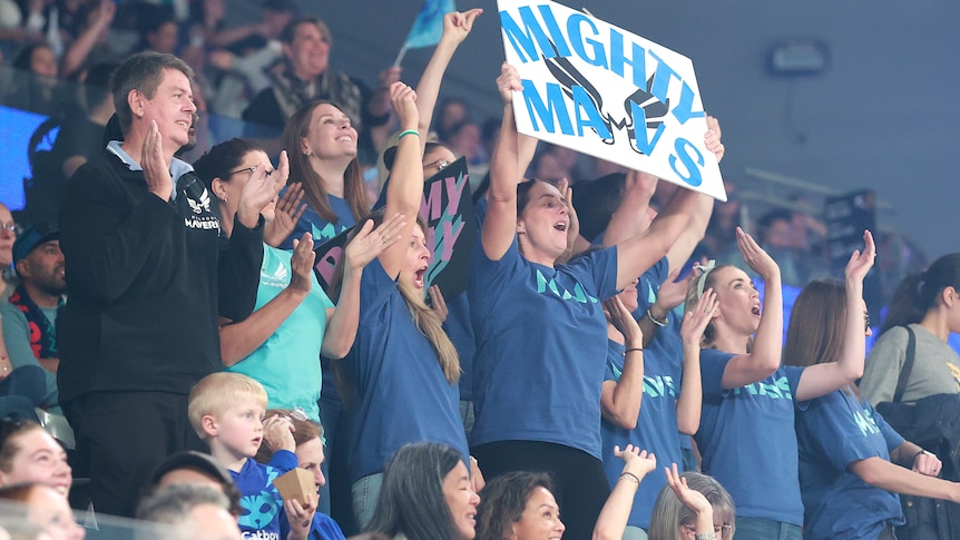 Fans hold up 'Mighty Mavs' signs in the stands
