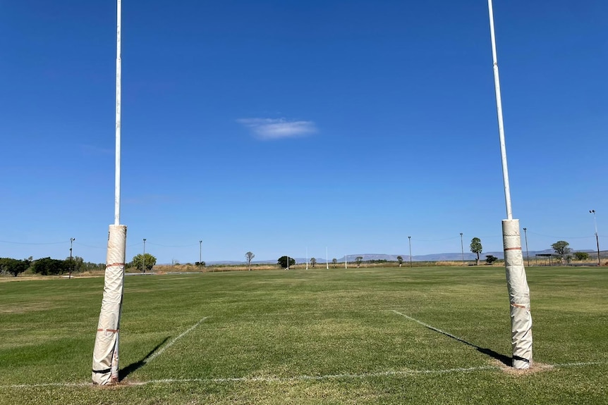 The view of an Aussie Rules ground from behind the goalposts on a clear sunny day
