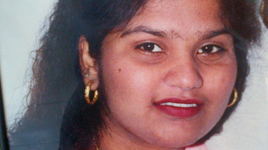 A women with dark hair and dark eyes smiles at the camera