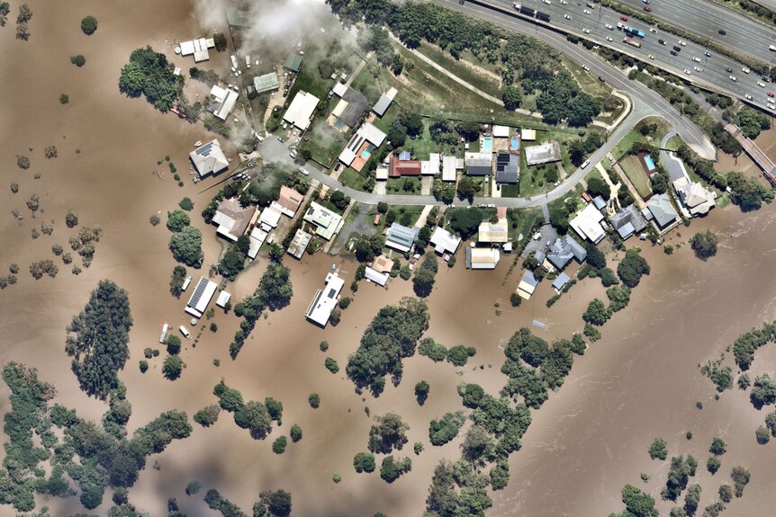 An aerial view of houses and backyards under water.