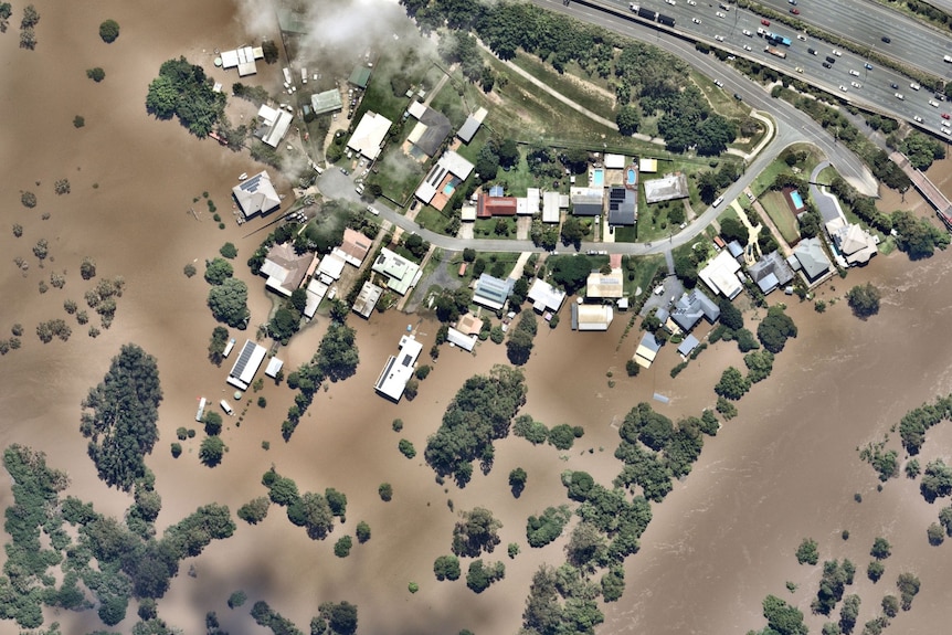 An aerial view of houses and backyards under water.