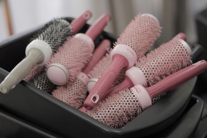 A hairdresser's cart filled with pink brushes