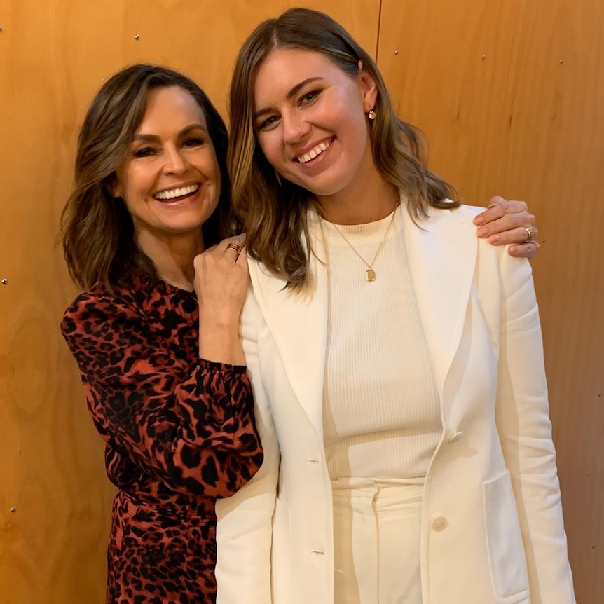 Two woman smile at the camera.