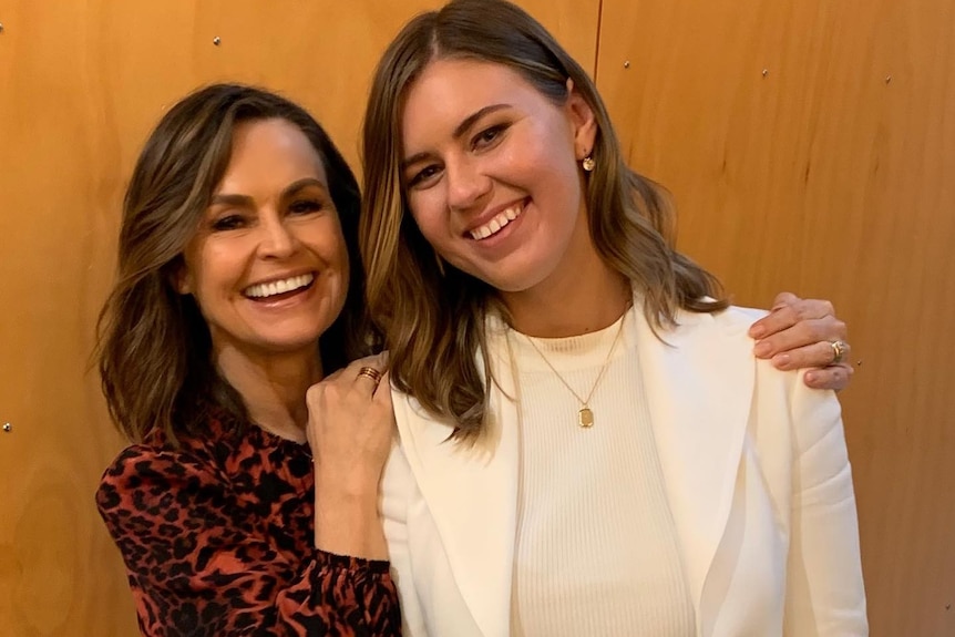 Two woman smile at the camera.