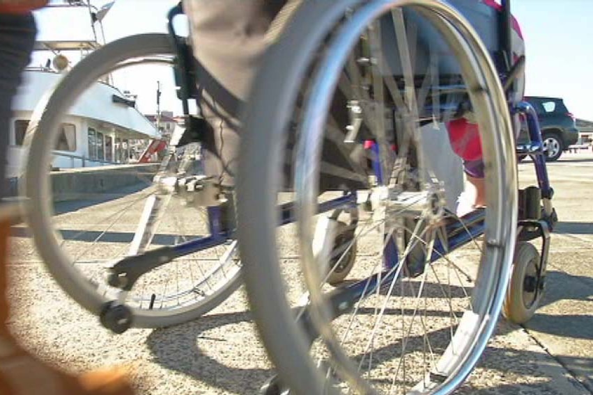 Close-up from ground level of a person using a wheelchair.