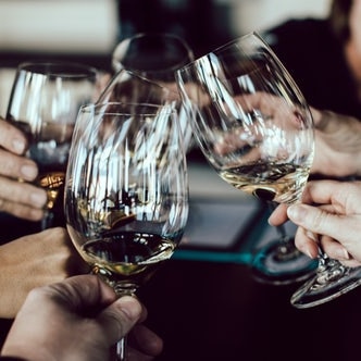 People holding wine glasses toasting, generic image.