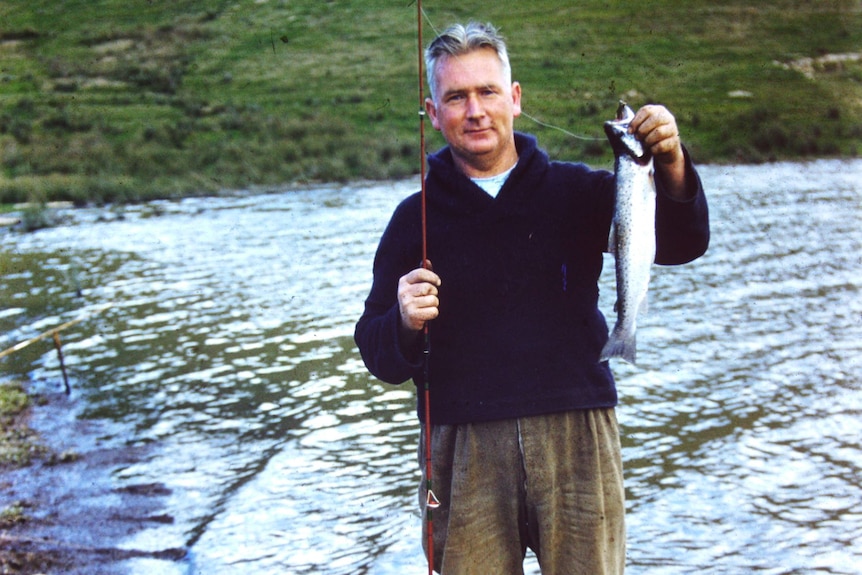 A man holding a fishing rod and a fish