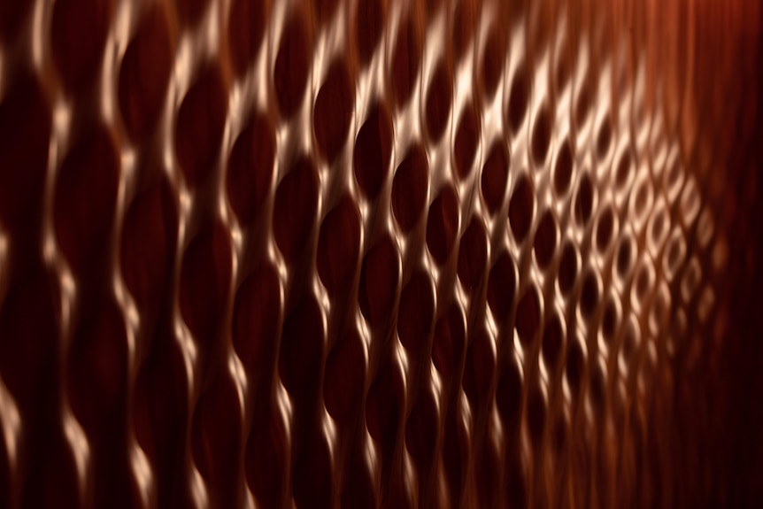 A close up of undulating wood paneling in the Opera House's Concert Hall that looks like wave ripples.