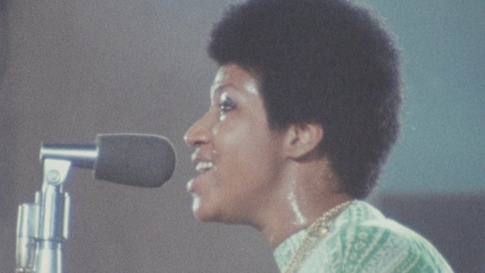 Aretha Franklin singing into a microphone and sweating, in the documentary film Amazing Grace