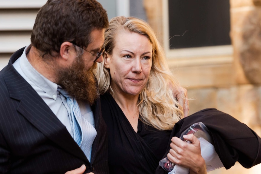 Tracey Bridgewater walks out of the Supreme Court with a man who has his arm around her shoulder.