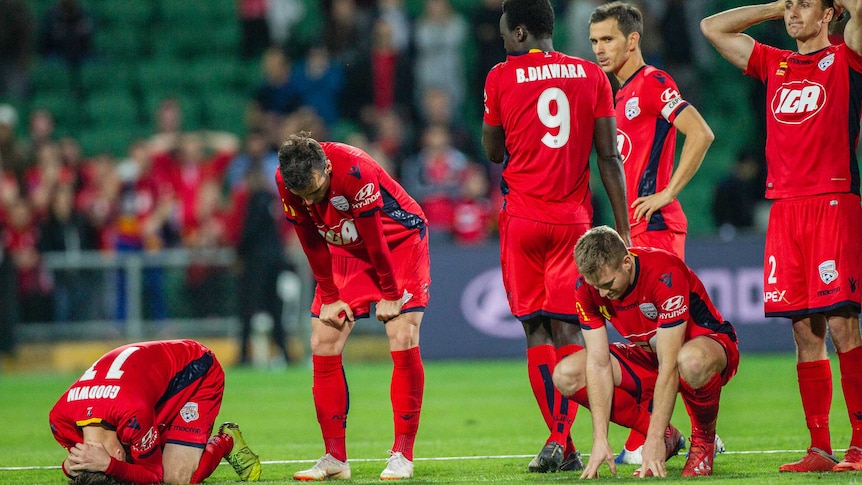 Football players console each other after a penalty shoot-out loss