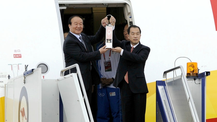 The Olympic torch flame is held by BOCOG executive vice president Xiaoya Jiang (left)