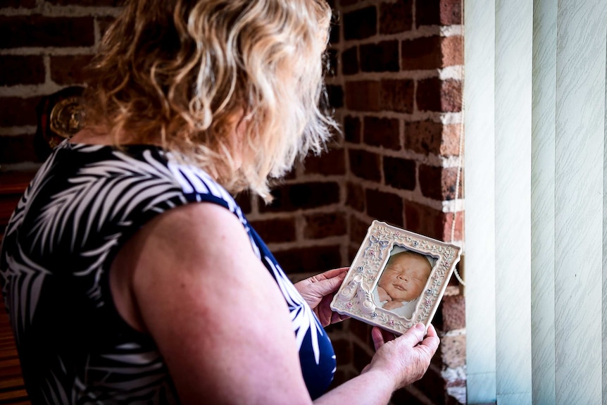 Vicki Walker looks at a baby photo of her son Clinton