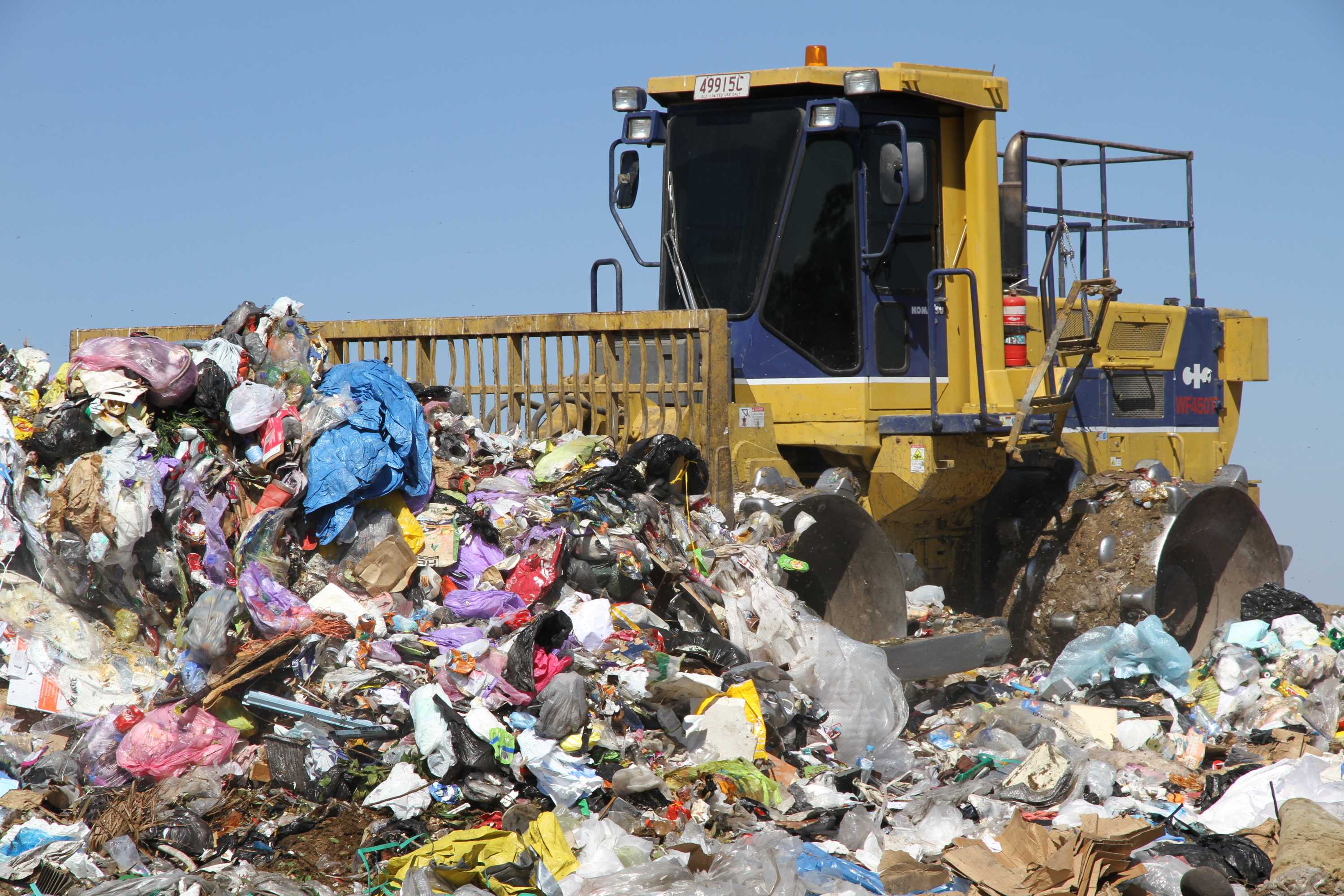 rubbish compactor pushing a pile of waste