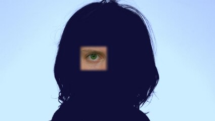 An image of an eye on a silhouette of a persons head and shoulders.