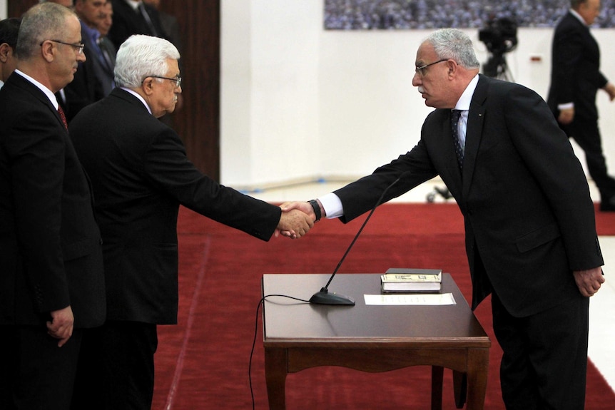 LtoR Mahmud Abbas shakes hands with Riyad Al-Maliki during swearing in.