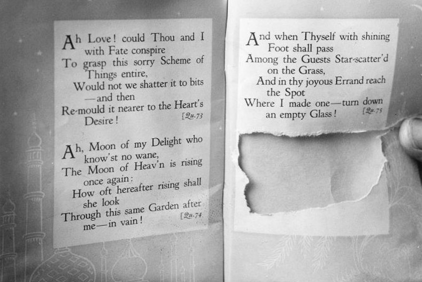 A black and white photo of a book with a section torn out.