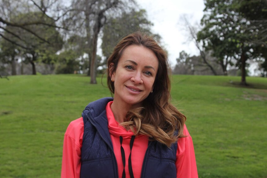Michelle Bridges looks towards the camera while standing in Melbourne's Royal Botanic Gardens.