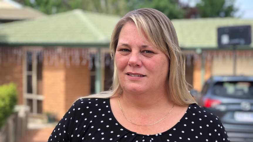 Karen Davidson stands in front of her home.