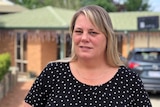 Karen Davidson stands in front of her home.