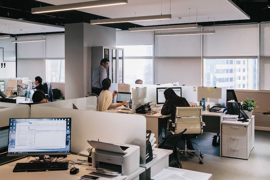 An open plan office with employees walking around