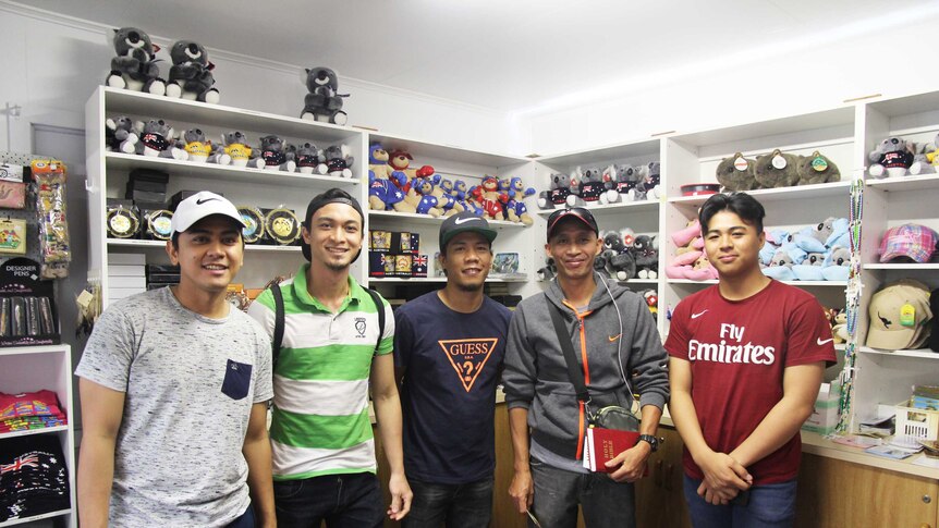Five men stand inside an Australiana gift shop