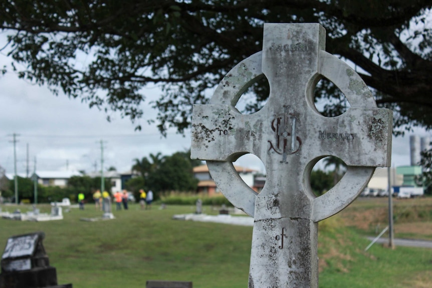 Memorial in forefront, volunteers working in distance