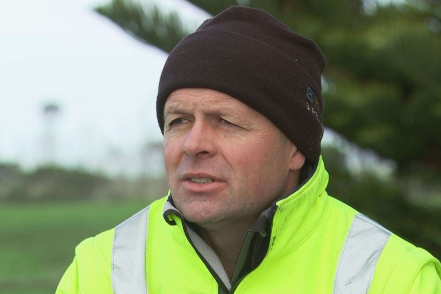 David Pollington wears a bright yellow jacket and a black beanie