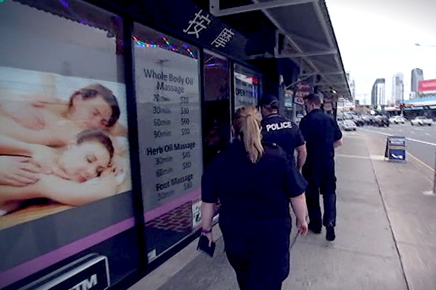 Officers from Queensland Police and Australian Border Force take part in a raid at a Mermaid Beach massage parlour
