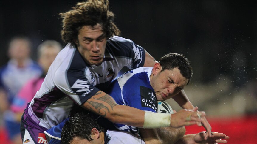 Copping it ... Jono Wright feels the full force of Kevin Proctor and Cooper Cronk's tackle.