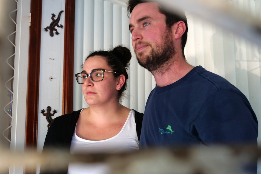 A woman and man with brown hair look away from the camera.