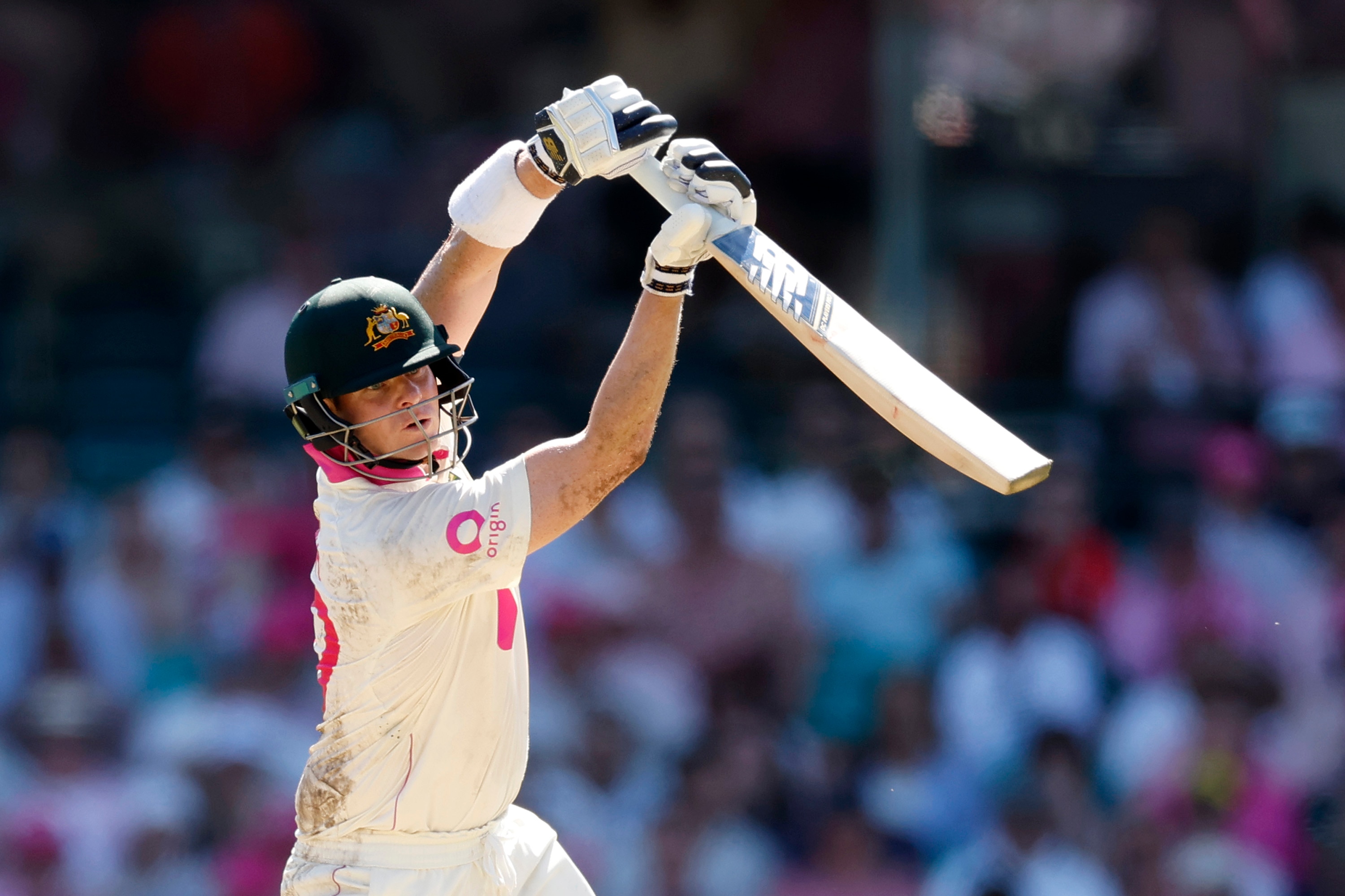 El bateador australiano Steve Smith termina un drive con su bate en el aire.