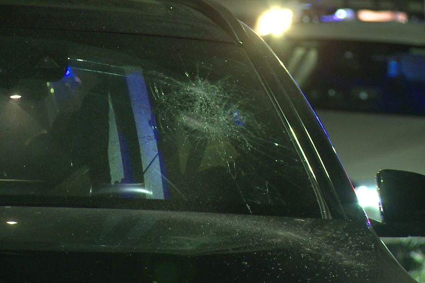 The smashed windscreen of a dark car