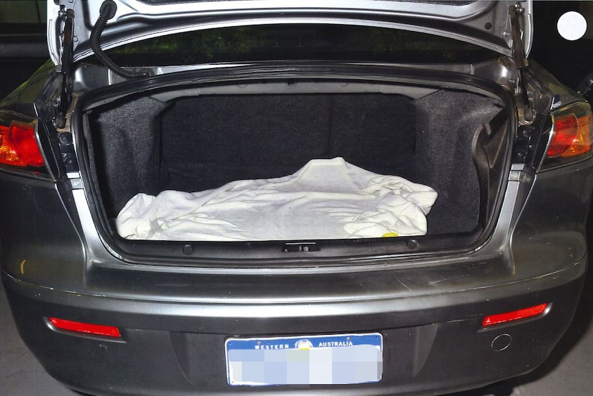 The boot of a car with a blanket inside.