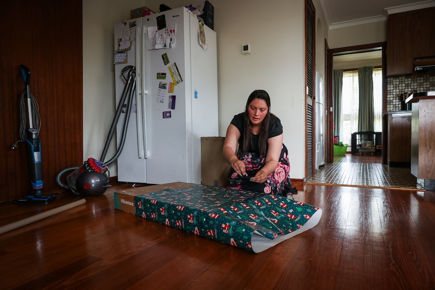 Kate Nicol envuelve un regalo de Navidad en su casa en los suburbios de Melbourne