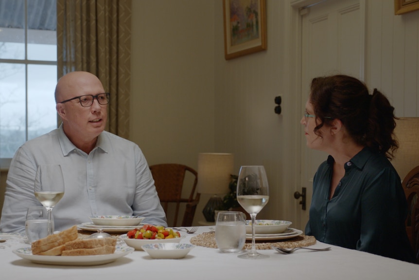 Peter Dutton and Annabel Crabb sitting at a dining table with two glasses of wine and dishes in front of them