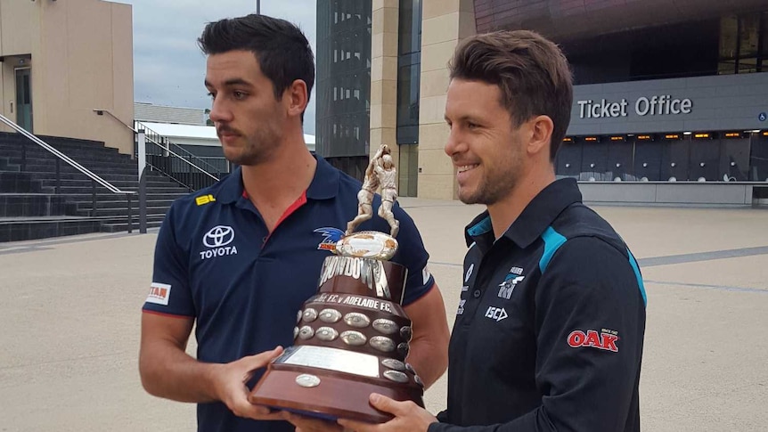 Adelaide Crows captain Taylor Walker and Port Adelaide captain Travis Boak with the Showdown trophy