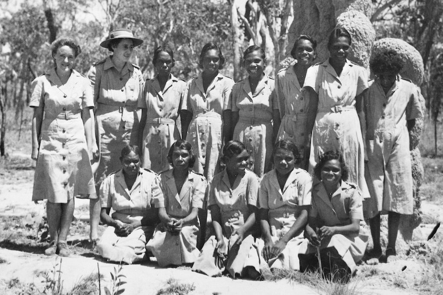 Corporal Dolly Garinyi Batcho sits in the front row of a group photo, with other women standing behind.
