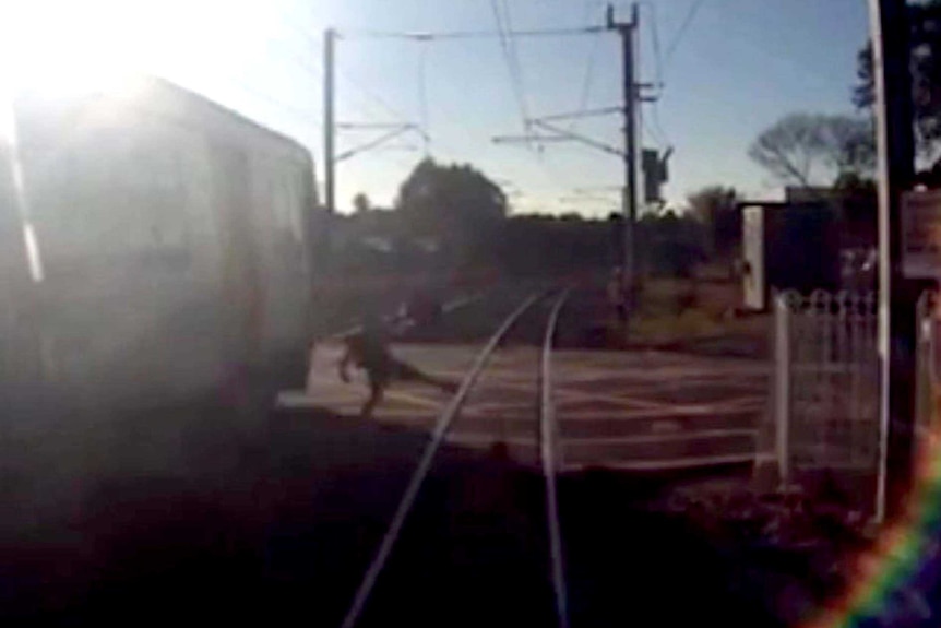 Video shows man's near miss at rail crossing