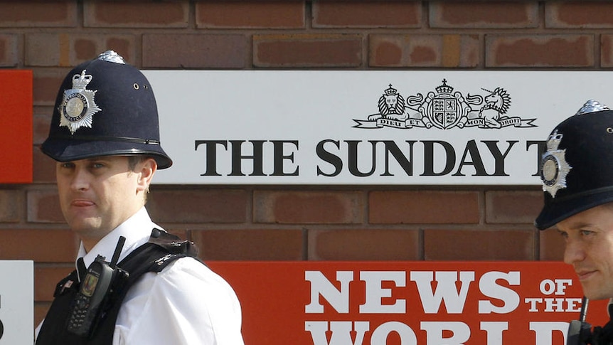 Police walk outside News International building