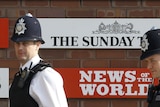 Police walk outside News International building