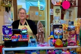 A woman behind the counter of a lolly shop.