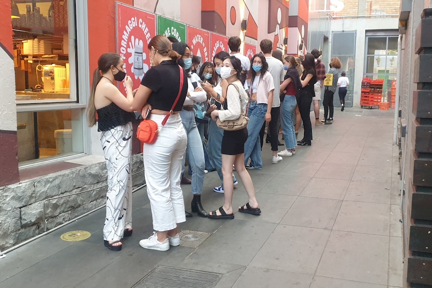 People line up outside a hospitality venue.