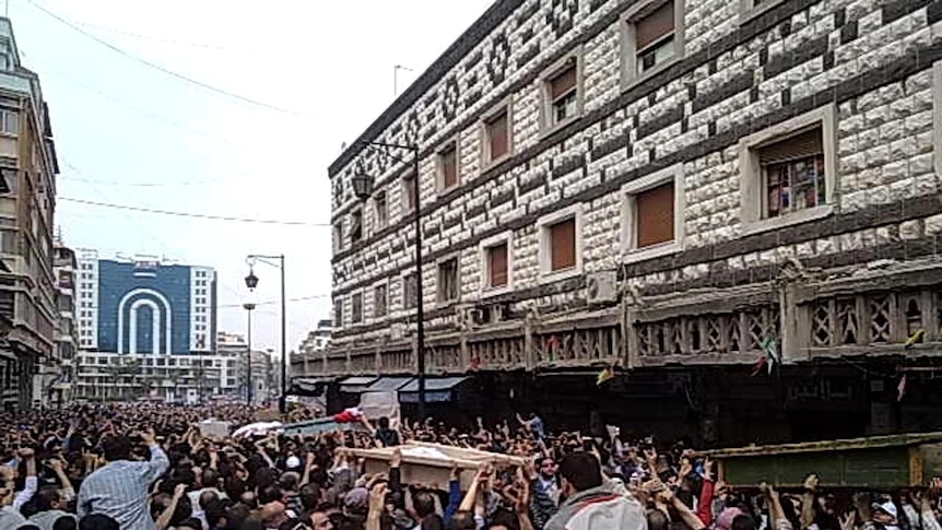 Thousands of Syrians attend a funeral in Homs