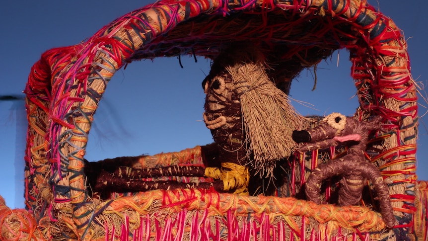 Woven models of a woman and her dog driving in a car.