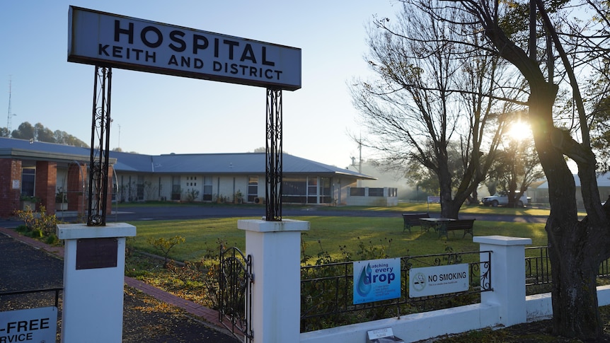An entry sign reading 'hospital keith and district' with a building and trees in the background