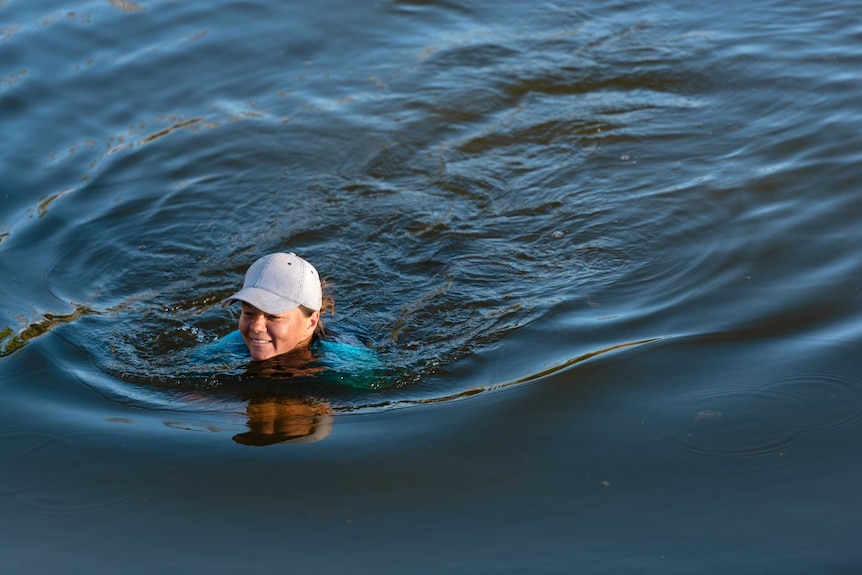 Jessica swims through water as part of the obstacle course.