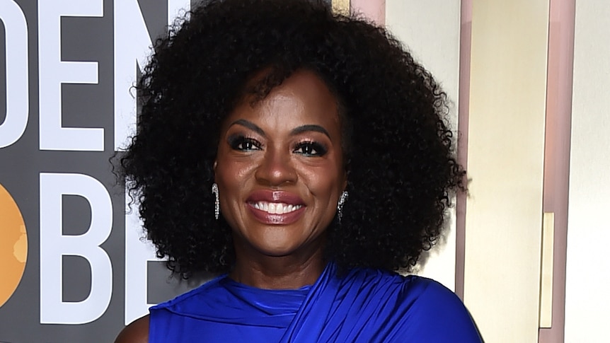 Viola Davis wearing a long cobalt blue gown with a train and one sleeve. 