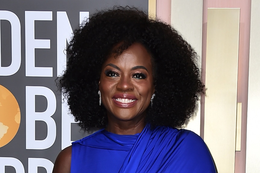 Viola Davis wearing a long cobalt blue gown with a train and one sleeve. 